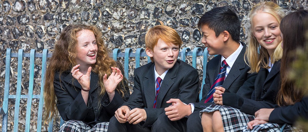 Younger co-ed pupils chatting on bench